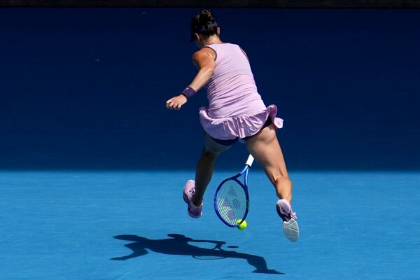 Belinda Bencic of Switzerland returns a shot between legs to Coco Gauff of the U.S. during their fourth round match at the Australian Open tennis championship in Melbourne, Australia, Sunday, Jan. 19, 2025. (AP Photo/Mark Baker)