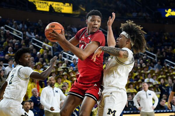 Rutgers guard Ace Bailey, middle, tries to get around Michigan guards Tre Donaldson, right, and L.J. Cason during the first half of an NCAA college basketball game, Thursday, Feb. 27, 2025, in Ann Arbor, Mich. (AP Photo/Jose Juarez)