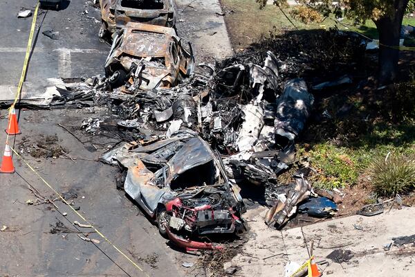 Debris covers the ground after a small plane crashed into a San Diego neighborhood, setting homes and cars on fire and forcing evacuations early Thursday, May 22, 2025. (AP Photo/William Liang)