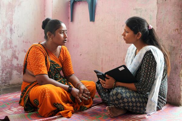 Data collector Komal Parmar, right, talks with Sapnaben Chunara to get heat related information in Ahmedabad, India, Wednesday, April 2, 2025. (AP Photo/Ajit Solanki)