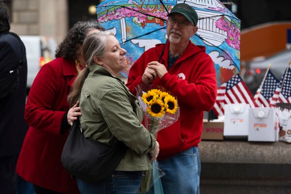 A United States Agency for International Development (USAID) worker holds a bouquet of flowers given to her after retrieving her personal belongings from USAID's headquarters in Washington, Thursday, Feb. 27, 2025. (AP Photo/Manuel Balce Ceneta)