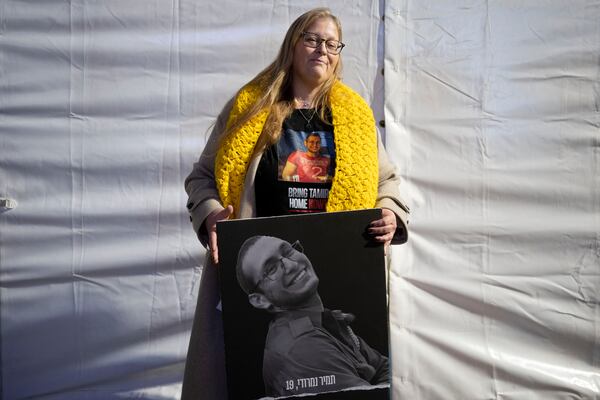 FILE - Herut Nimrodi poses for a portrait with a poster of her son, Tamir Nimrodi, an Israeli soldier taken hostage on Oct. 7, 2023, and being held by Hamas militants in the Gaza Strip, at a rally for hostages and their families in Tel Aviv, Israel, Jan. 14, 2025. (AP Photo/Maya Alleruzzo, File)