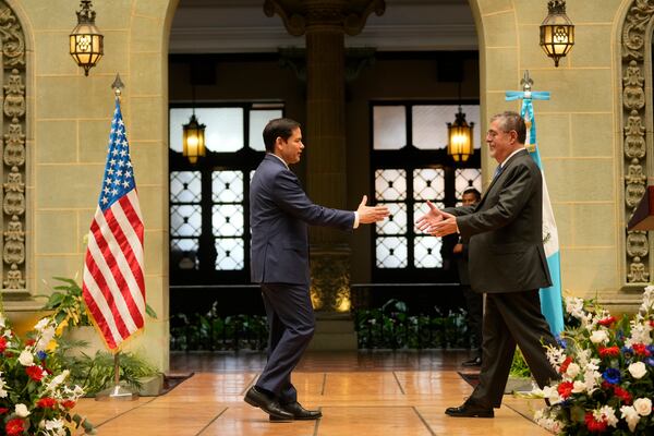 U.S. Secretary of State Marco Rubio, left, and Guatemalan President Bernardo Arevalo reach out to shake hands at the end of their joint news conference at the National Palace in Guatemala City, Wednesday, Feb. 5, 2025. (AP Photo/Mark Schiefelbein, Pool)