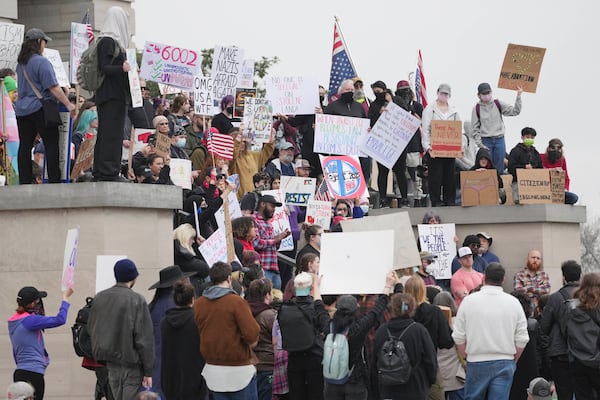 Protesters hold up signs while gathering at the capitol, Wednesday, Feb. 5, 2025, in Nashville, Tenn. (AP Photo/George Walker IV)