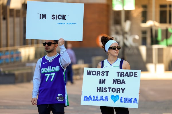 Ryan Safdarinia, left, and Lillian McCall hold signs reacting to the news that the Dallas Mavericks traded Luka Doncic to the Los Angeles Lakers outside the American Airlines Center, Sunday, Feb. 2, 2025, in Dallas. (Elias Valverde II/The Dallas Morning News via AP)