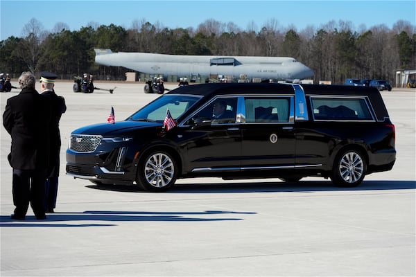 The hearse carrying the flag-draped casket of former President Jimmy Carter arrives at Dobbins Air Reserve Base in Marietta, Ga., Tuesday, Jan. 7, 2025. Carter died Dec. 29 at the age of 100. (AP Photo/Alex Brandon, Pool)