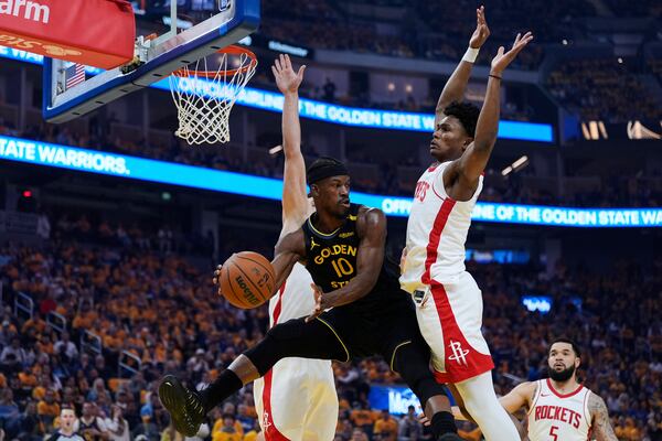Golden State Warriors forward Jimmy Butler III (10) passes the ball between Houston Rockets center Alperen Sengun, left, and forward Amen Thompson during the first half of Game 6 of an NBA basketball first-round playoff series Friday, May 2, 2025, in San Francisco. (AP Photo/Godofredo A. Vásquez)