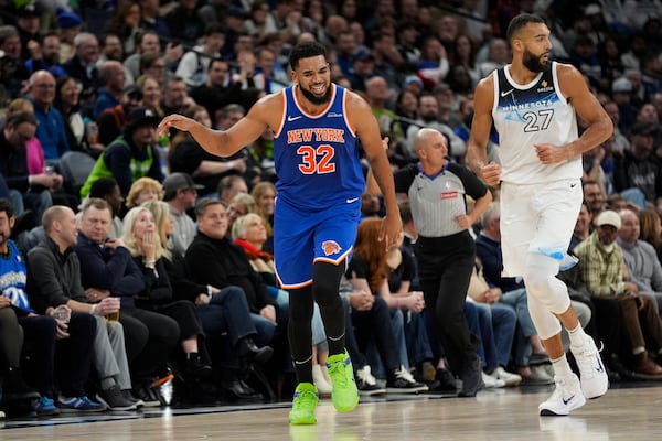 New York Knicks center Karl-Anthony Towns (32) celebrates after making a 3-point basket over Minnesota Timberwolves center Rudy Gobert (27) during the first half of an NBA basketball game, Thursday, Dec. 19, 2024, in Minneapolis. (AP Photo/Abbie Parr)