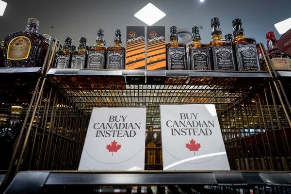 A sign is placed in front of the American whiskey section at a B.C. Liquor Store before top selling American made products are to be removed from shelves as a demonstration for media in Vancouver, B.C., Sunday, Feb. 2, 2025. (Ethan Cairns/The Canadian Press via AP)