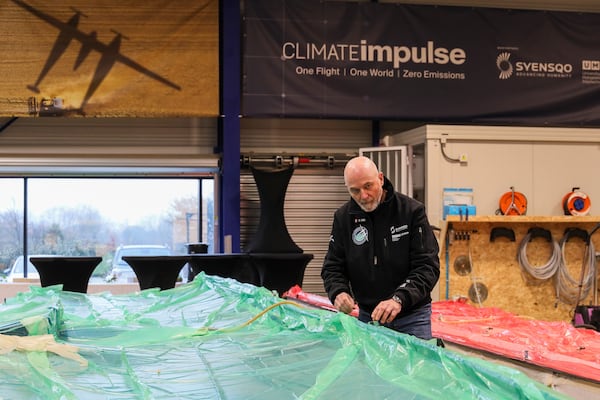 Raphael Dinelli, Climate Impulse engineer and co-pilot, stands near wings of the plane, powered by liquid hydrogen, at a press presentation of the project in a hangar in Les Sables d'Olonne, France on Thursday, Feb. 13, 2025.(AP Photo/Yohan Bonnet)