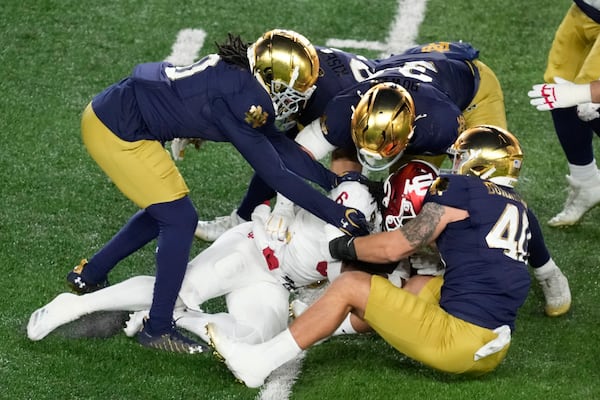 Notre Dame defenders stop Indiana running back Justice Ellison (6) during the first half in the first round of the NCAA College Football Playoff, Friday, Dec. 20, 2024, in South Bend, Ind. (AP Photo/Darron Cummings)