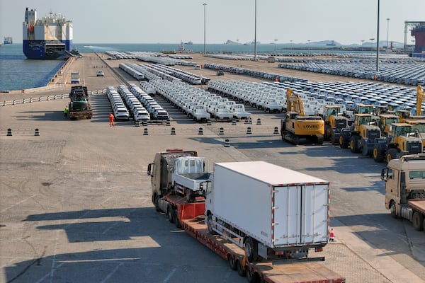 A truck loaded with vehicles moves to lines of vehicles for export at a port in Yantai in eastern China's Shandong province on Jan. 2, 2025. (Chinatopix via AP)