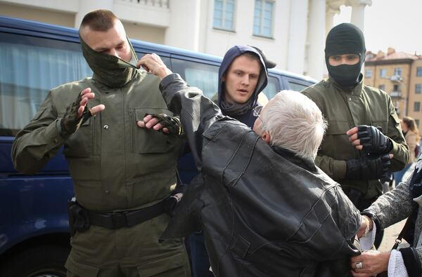 FILE - Opposition activist Nina Bahinskaya, 73, rips the mask off a police officer during an opposition rally to protest the official presidential election results in Minsk, Belarus, Saturday, Sept. 12, 2020. (Tut.by via AP, File)
