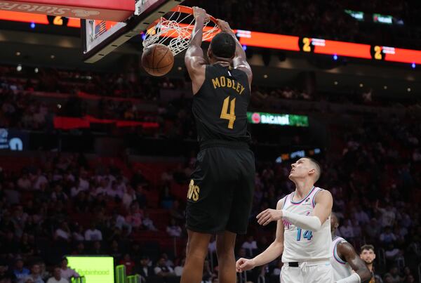 Cleveland Cavaliers forward Evan Mobley (4) dunks over Miami Heat guard Tyler Herro (14) during the second half of an NBA basketball game, Wednesday, Jan. 29, 2025, in Miami. (AP Photo/Lynne Sladky)