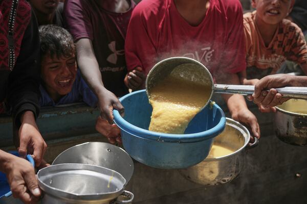 Palestinian children struggle to get donated food at a community kitchen in Khan Younis, southern Gaza Strip, Thursday April 24, 2025.(AP Photo/Abdel Kareem Hana)