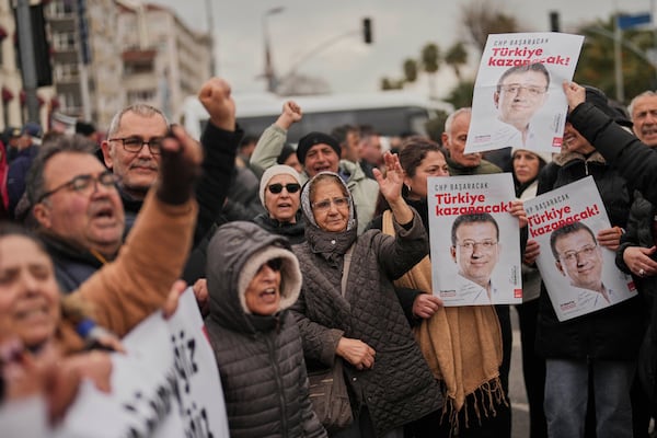 People chant slogans and hold posters of Istanbul Mayor Ekrem Imamoglu as they protest outside the Vatan Security Department, where Imamoglu is expected to be taken following his arrest in Istanbul, Turkey, Wednesday, March 19, 2025. (AP Photo/Francisco Seco)