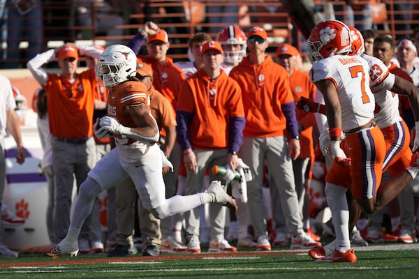 Texas running back Jaydon Blue, left, runs from Clemson safety Khalil Barnes (7) during a 38-yard touchdown run in the first half in the first round of the College Football Playoff, Saturday, Dec. 21, 2024, in Austin, Texas. (AP Photo/Eric Gay)