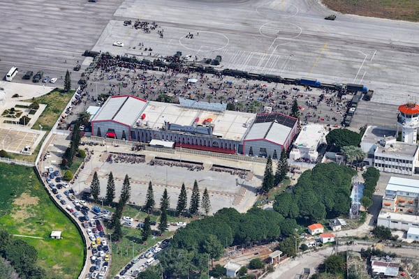 This aerial view shows hundreds of people who fled sectarian violence last week seeking refuge on the tarmac of Russia's airbase in Hmeimim, Latakia province, Syria, Wednesday, March 13, 2025. Thousands of Syrians are still sheltering at the Russian airbase, according to a Russian official. (AP Photo)