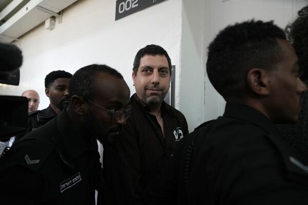 Bookseller Ahmad Muna is led into court after his arrest during an Israeli police have raid of the long-established Palestinian-owned Educational Bookshop in east Jerusalem, Monday, Feb. 10, 2025. (AP Photo/Mahmoud Illean)