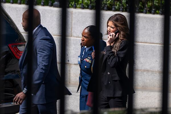 Homeland Security Secretary Kristi Noem, right, walks to the White House, Wednesday, April 30, 2025, in Washington. (AP Photo/Alex Brandon)