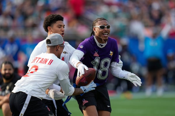 NFC wide receiver Justin Jefferson (18), of the Minnesota Vikings, scores a touchdown next to AFC cornerback Pat Surtain II, of the Denver Broncos, left, and safety Kyle Hamilton, of the Baltimore Ravens, during the flag football event at the NFL Pro Bowl, Sunday, Feb. 2, 2025, in Orlando. (AP Photo/Chris O'Meara)