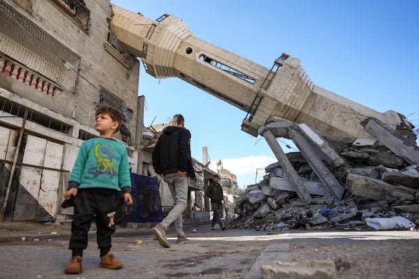 Palestinians walk past a mosque destroyed by the Israeli airstrikes in Nuseirat, Gaza Strip, Friday, Jan. 24, 2025 days after the ceasefire deal between Israel and Hamas came into effect. (AP Photo/Abdel Kareem Hana)