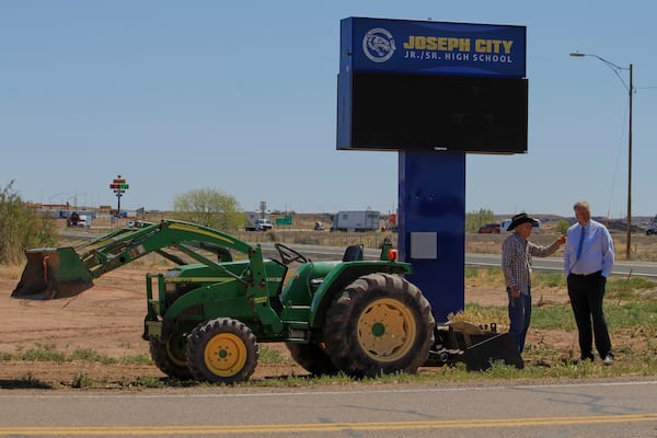 Rancher Brantley Baird, left, and Joseph City School Superintendent Bryan Fields discuss a historical marker near the high school sign in Joseph City, Ariz., Wednesday, April 23, 2025. (AP Photo/Susan Montoya Bryan)