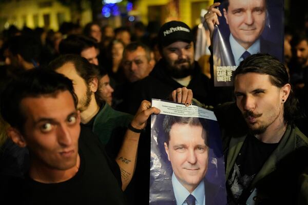Supporters of presidential candidate Nicusor Dan celebrate on the street after polls closed for the second round of the country's presidential election redo in Bucharest, Romania, early Monday, May 19, 2025. (AP Photo/Vadim Ghirda)