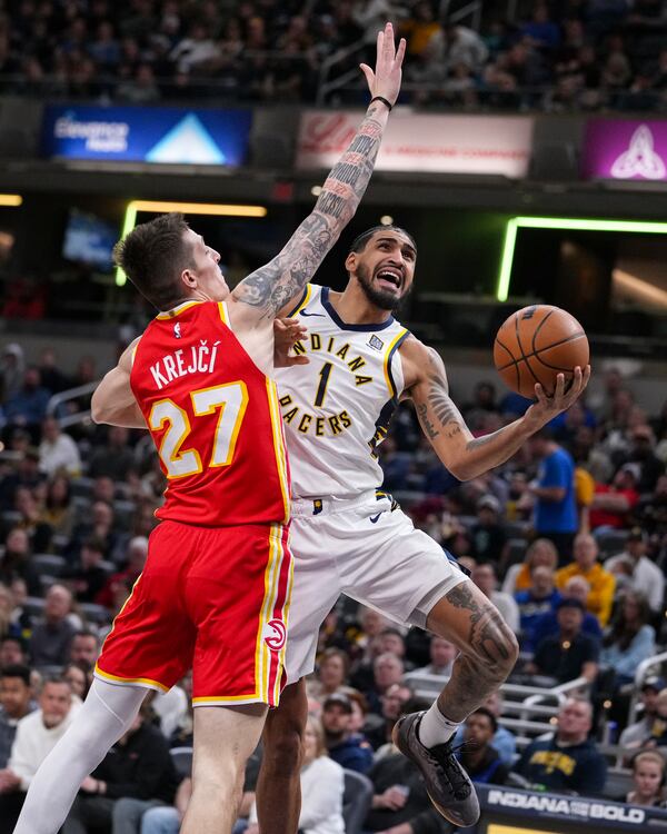 Indiana Pacers forward Obi Toppin (1) shoots around Atlanta Hawks guard Vit Krejci (27) during the second half of an NBA basketball game in Indianapolis, Saturday, Feb. 1, 2025. (AP Photo/Michael Conroy)