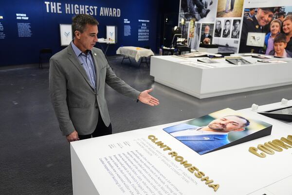 Chris Cassidy, chief executive officer of the National Medal of Honor Museum, gestures to an image of MOH recipient Clint Romesha as Cassidy responds to a question during an interview at the museum in Arlington, Texas, Thursday, March 13, 2025. (AP Photo/Tony Gutierrez)