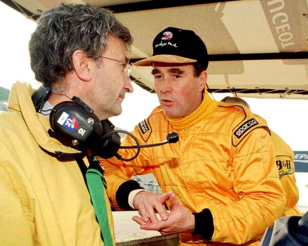 FILE - Britain's Nigel Mansell, right, speaks with Jordan-Peugeot team owner Edddie Jordan of Ireland on the pit wall at the Montmelo circuit in Barcelona Wednesday, Dec. 11, 1996. (AP Photo/Cesar Rangel, File)