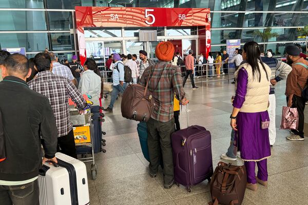 Passengers wait for the information on flights destined for the Heathrow Airport in London, outside the Indira Gandhi International Airport, in New Delhi, India, Friday, March 21, 2025. (AP Photo/Shonal Ganguly)