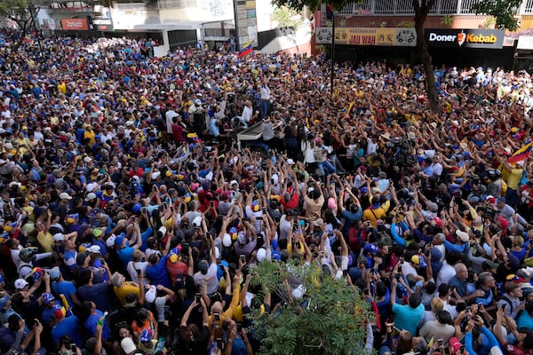 Venezuelan opposition leader Maria Corina Machado waves from the top of a truck, surrounded by supporters, as they protest Venezuelan President Nicolas Maduro the day before his inauguration for a third term in Caracas, Venezuela, Thursday, Jan. 9, 2025. (AP Photo/Ariana Cubillos)