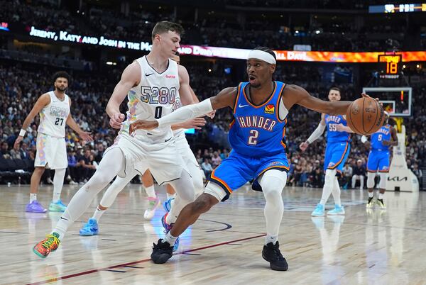 Oklahoma City Thunder guard Shai Gilgeous-Alexander, right, drives to the basket as Denver Nuggets guard Christian Braun defends in the second half of Game 6 in the Western Conference semifinals of the NBA basketball playoffs Thursday, May 15, 2025, in Denver. (AP Photo/David Zalubowski)