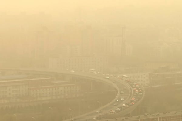 FILE - Cars drive along a highway shot through a glass window during a dust storm amid heavy pollution in Beijing, March 10, 2023. Almost the entire world breathes air that exceeds the World Health Organization's air-quality limits at least occasionally. (AP Photo/Borg Wong, File)