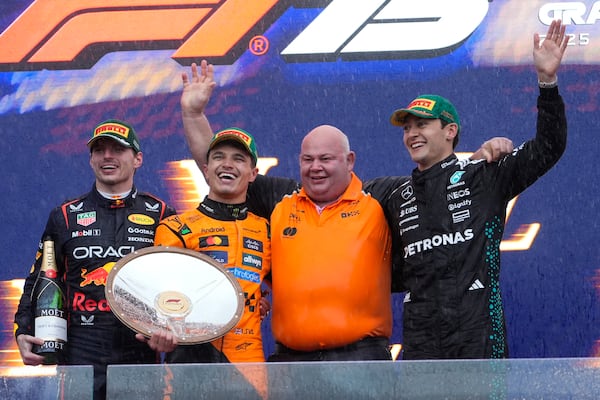 Race winner McLaren driver Lando Norris of Britain, second left, stands with second placed Max Verstappen, left, of the Netherlands, Rob Marshall, chief designer of McLaren and third placed Mercedes driver George Russell, right, of Britain on the podium following the Australian Formula One Grand Prix at Albert Park, in Melbourne, Australia, Sunday, March 16, 2025. (AP Photo/Asanka Brendon Ratnayake)