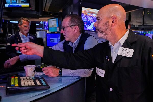 Specialist Glenn Carell, center, and trader Fred Demarco, right, work on the floor of the New York Stock Exchange, Friday, May 9, 2025. (AP Photo/Richard Drew)