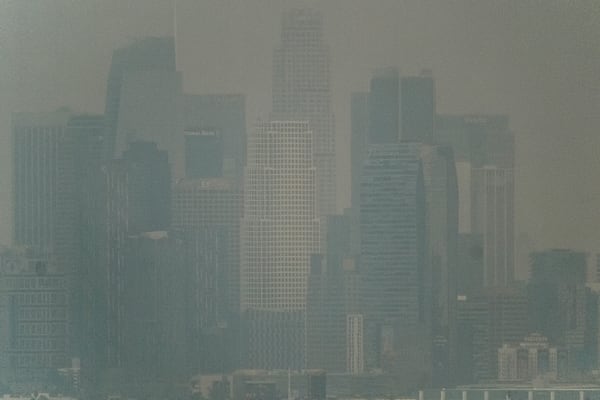 Thick heavy black smoke from wildfires shrouds buildings in downtown Los Angeles on Wednesday, Jan. 8, 2025. (AP Photo/Richard Vogel)