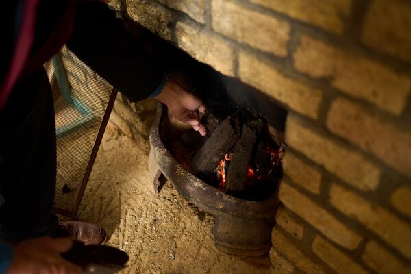 A local activist opposing the construction of wind farms burns peat in a fireplace, in Lemanaghan, Ireland, Wednesday, Oct. 16, 2024. (AP Photo/Bram Janssen)