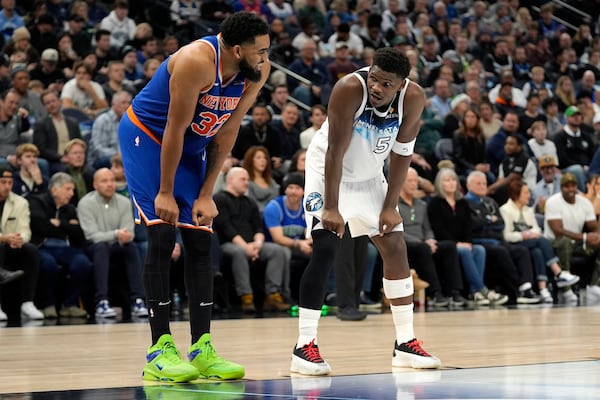 New York Knicks center Karl-Anthony Towns (32) and Minnesota Timberwolves guard Anthony Edwards (5) talk during the first half of an NBA basketball game, Thursday, Dec. 19, 2024, in Minneapolis. (AP Photo/Abbie Parr)