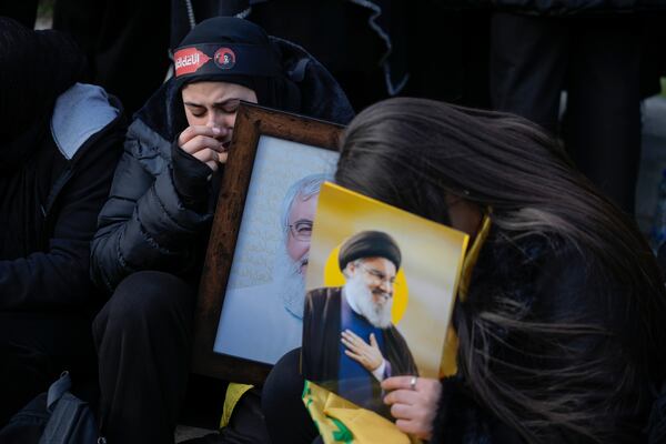 Mourners hold pictures of Hezbollah's former leader Hassan Nasrallah, right, and his cousin and successor Hashem Safieddine as they gather to attend their funeral procession in Beirut, Lebanon, Sunday Feb. 23, 2025. (AP Photo/Bilal Hussein)