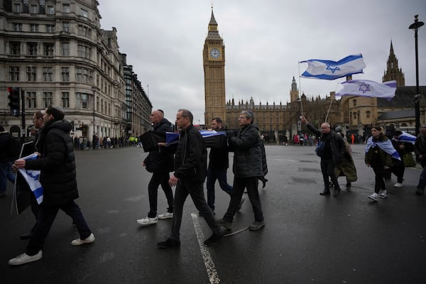 Mock coffins are carried through Westminster in London, Thursday, Feb. 20, 2025 to mourn hostages who have died in Gaza and demand the release of the remaining captives. (AP Photo/Kin Cheung)