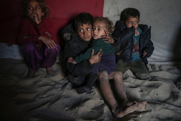 Palestinian Tamim Marouf, 6, sits inside his family's tent alongside his sister Hala, 10, and his brother Malek, 4, at a camp for internally displaced Palestinians on the beachfront in Deir al-Balah, central Gaza Strip, Friday, Dec. 27, 2024. (AP Photo/Abdel Kareem Hana)