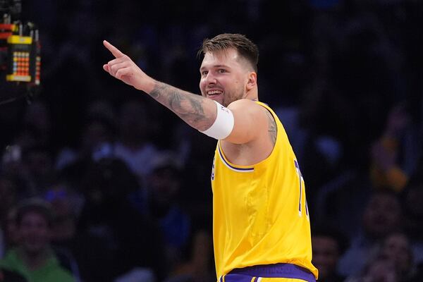 Los Angeles Lakers guard Luka Doncic gestures toward forward LeBron James after he scored with an assist by James during the first half of an NBA basketball game against the Minnesota Timberwolves, Thursday, Feb. 27, 2025, in Los Angeles. (AP Photo/Mark J. Terrill)