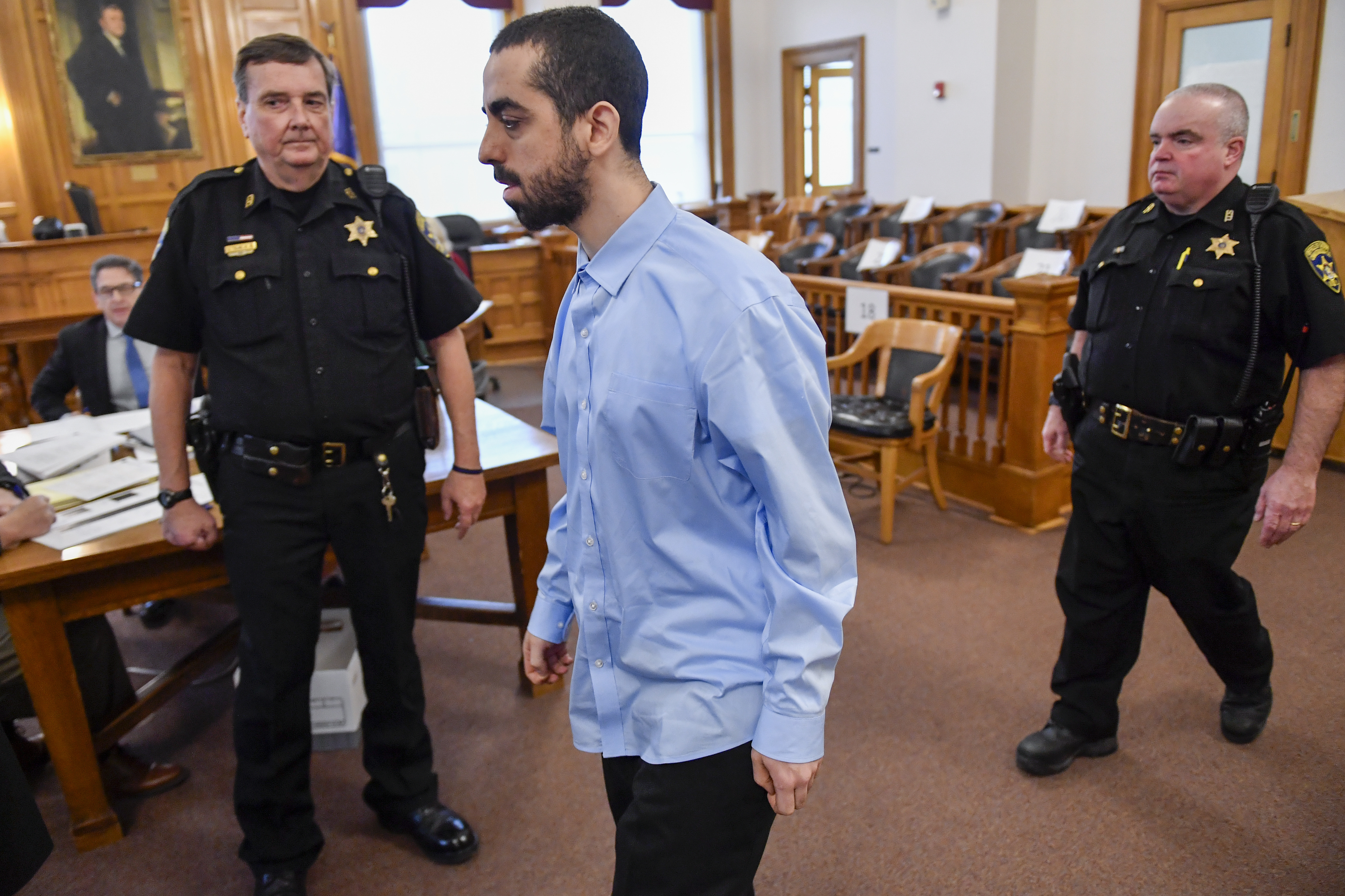 Hadi Matar, center, charged with severely injuring author Salman Rushdie in a 2022 knife attack, is led into Chautauqua County court before the start of jury selection in Mayville, N.Y., Tuesday, Feb. 4, 2025. (AP Photo/Adrian Kraus)