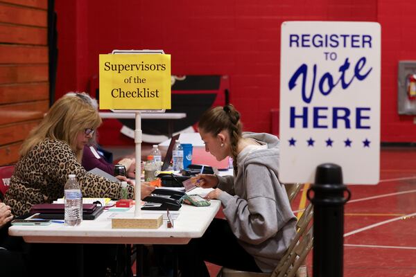 Supervisor of the Checklist for the State of New Hampshire Leslie Dombroski, left, registers Elise Collins, 18, to vote in Derry, N.H., Tuesday, March 11, 2025. (AP Photo/Reba Saldanha)