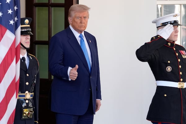 President Donald Trump gives a thumbs-up as he waits to greet France's President Emmanuel Macron before a news conference at the White House, Monday, Feb. 24, 2025, in Washington. (AP Photo/Manuel Balce Ceneta)