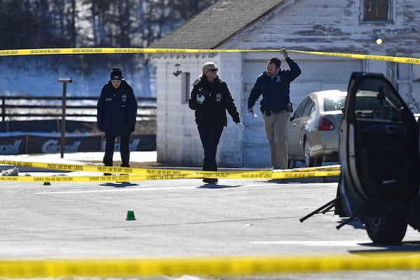 Detectives with the Louisville Metro Crime Scene unit examines a scene of a deadly shooting outside a motor vehicle office in Louisville, Ky., Friday, Feb. 21, 2025. (AP Photo/Timothy D. Easley)