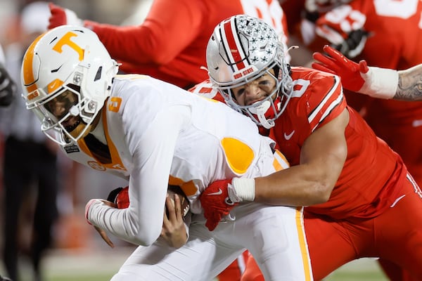 Ohio State linebacker Cody Simon, right, tackles Tennessee quarterback Nico Iamaleava, left, during the first half in the first round of the College Football Playoff, Saturday, Dec. 21, 2024, in Columbus, Ohio. (AP Photo/Jay LaPrete)