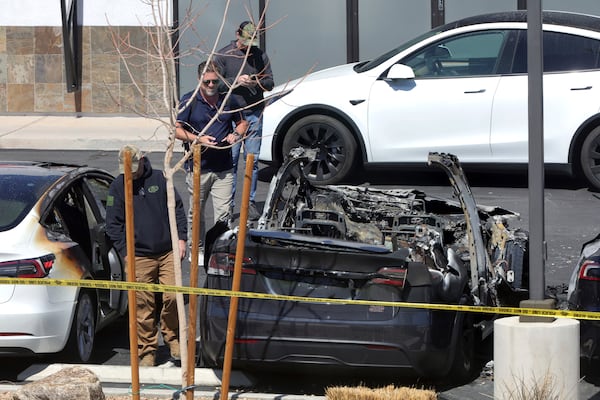 Law enforcement officials investigate vehicle fires at a Tesla collision center Tuesday, March 18, 2025, in Las Vegas. (Steve Marcus/Las Vegas Sun via AP)